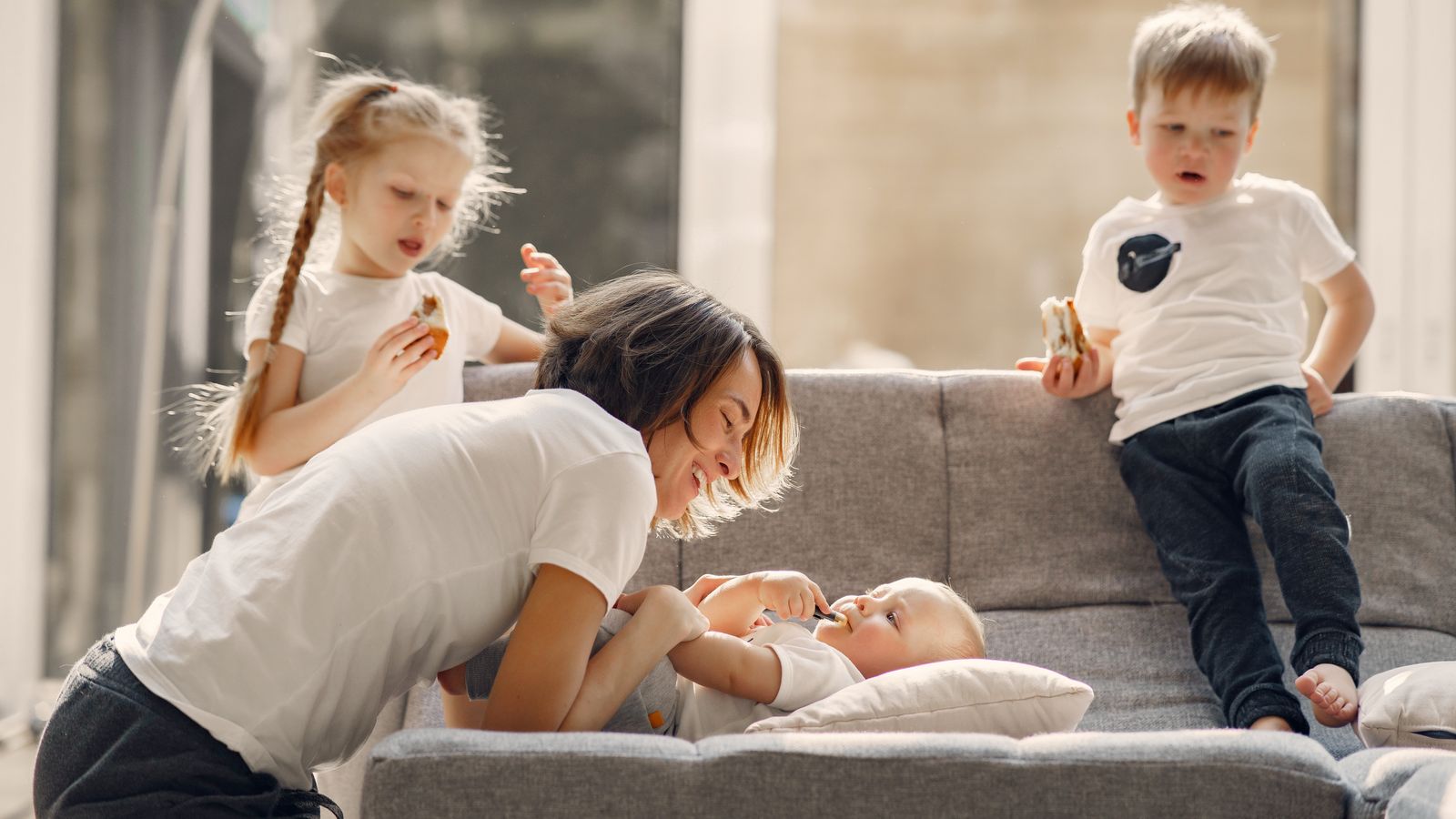 Mother playing with her young children at home
