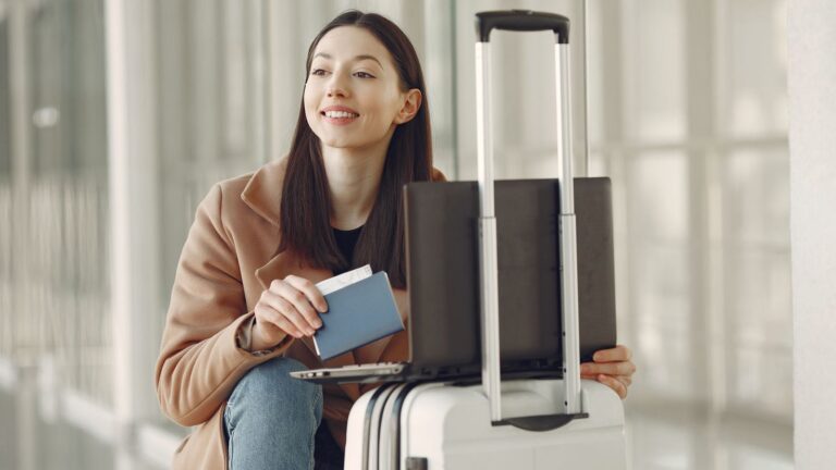 Traveller with a passport and suitcase in an airport terminal