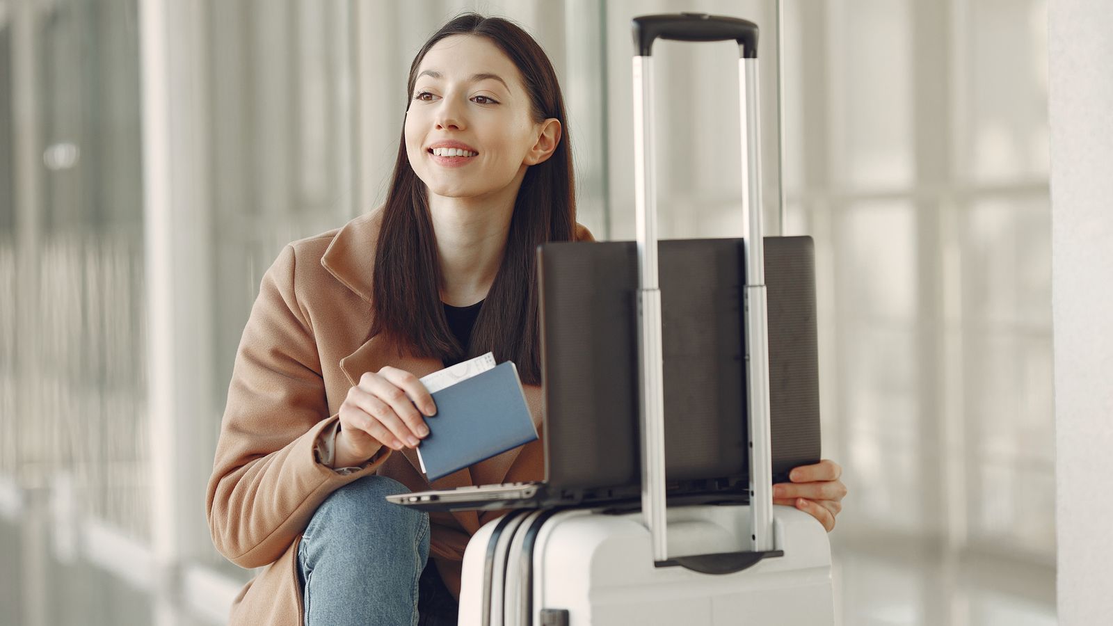 Traveller with a passport and suitcase in an airport terminal