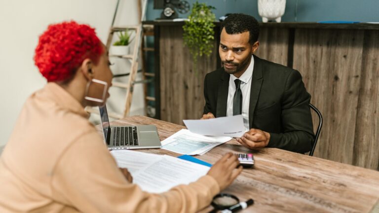 Tax advisor meeting a client across a desk with documents